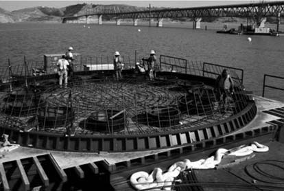 concrete cofferdam being formed on a barge
