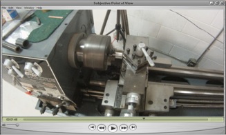 This image is a screenshot of video showing how to assemble a lathe. The picture is taken from above as if a person is looking down on the lathe part.